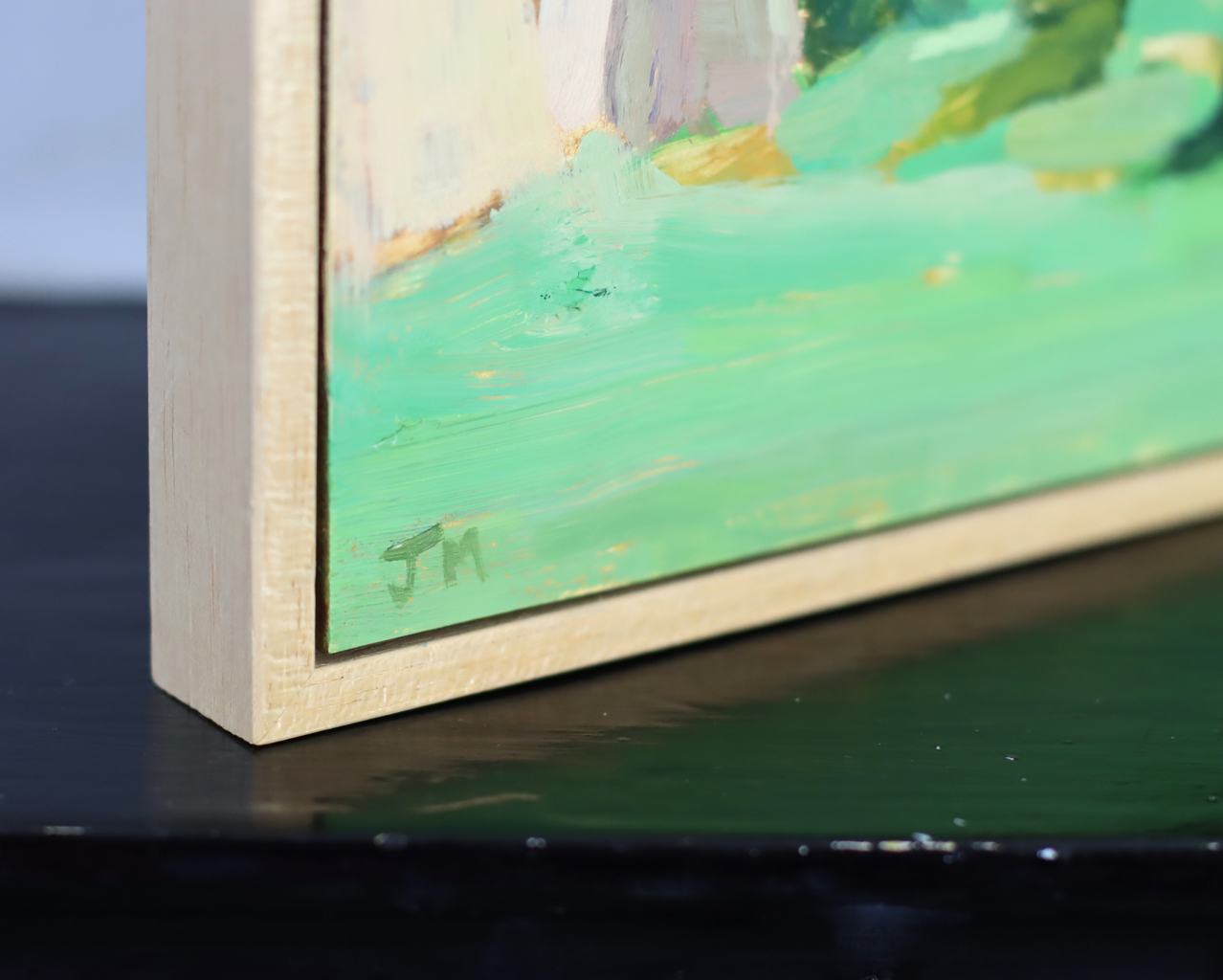 Corner of painting with a light wood float frame