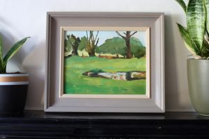 Landscape in greens and browns with reflections in the water